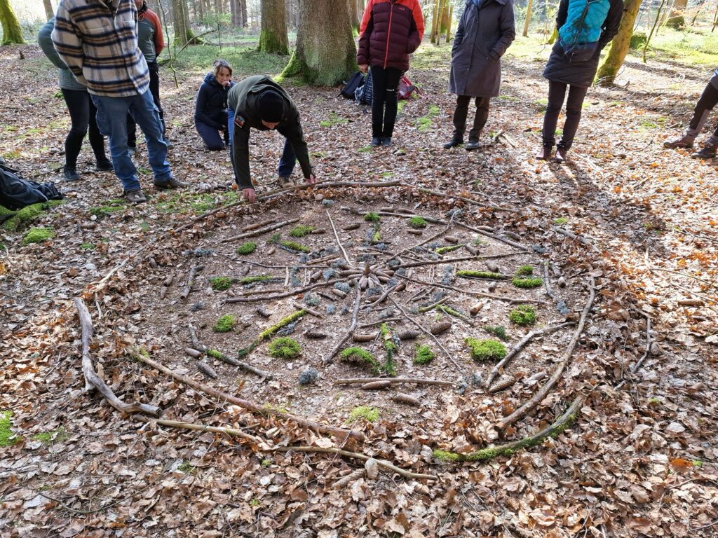 Menschen legen Mandala auf Waldboden