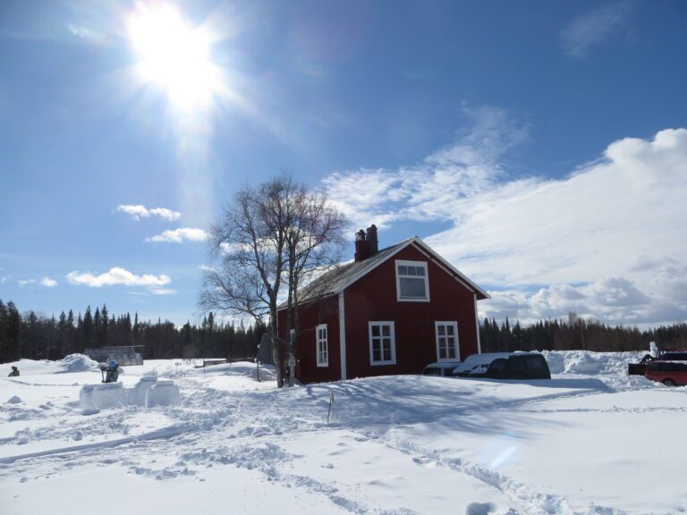 Schwedenhaus mit Sonne im Schnee in Solberget nördlich vom Polarkreis